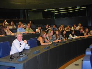 Adrian listens to the presentation - surrounded by students