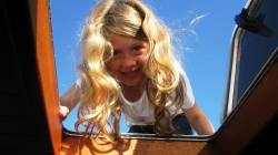 Eve looks down through boat skylight- note clear blue sky